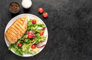 grilled chicken breast and cherry tomato salad on stone background
