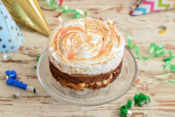 Stand with tasty birthday cake and confetti on light wooden background