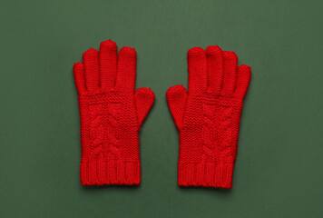 Pair of warm gloves on green background
