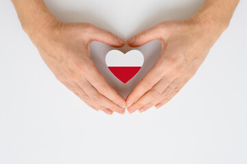 The national flag of Poland in female hands. The concept of patriotism, respect and solidarity with the citizens of Poland.