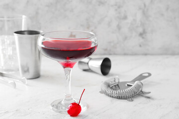 Glass of tasty Manhattan cocktail on light background
