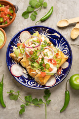 Mexican fried potato tacos called flautas with guacamole and cheese