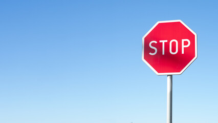Fototapeta STOP - Czerwony znak stop na niebieskim tle, zatrzymać się , symbol, sprzeciw obraz