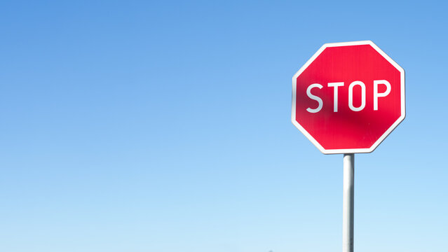 STOP - Czerwony znak stop na niebieskim tle, zatrzymać się , symbol, sprzeciw
