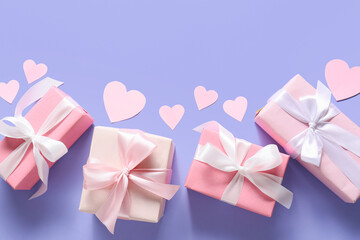 Different gift boxes and paper hearts on color background. Valentine's Day celebration