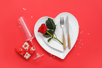 Stylish table setting, rose and gift for Valentine's Day on red background
