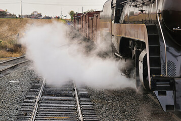 An Antique Restored Steam Freight Train Approaching Head on Blowing Smoke and Steam