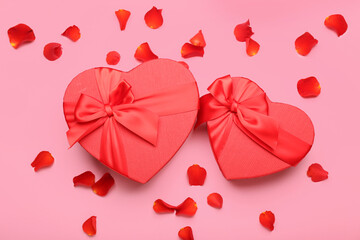 Gift boxes for Valentine's Day and rose petals on pink background