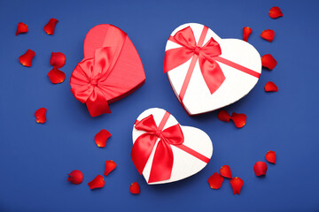 Gift boxes for Valentine's Day and rose petals on blue background