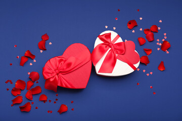Gift boxes for Valentine's Day and rose petals on blue background