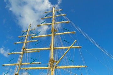 Two masts of a sailboat against the blue sky.