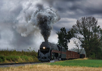 Fototapeta na wymiar An Antique Restored Steam Freight Train Approaching Head on Blowing Smoke and Steam