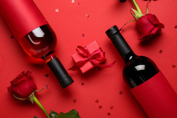 Bottles of wine, roses and gift for Valentine's Day on red background