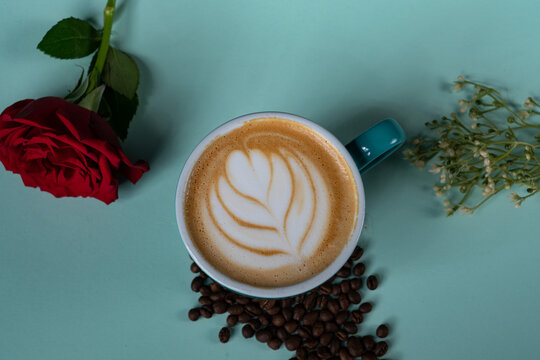 cup of coffee with rose ant art from top shot