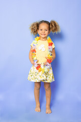 Full length photo of excited charming cute little girl with Happy little girl wearing Hawaiian necklace standing isolated over purple background.