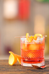 Glass of tasty Negroni cocktail on table against blurred background