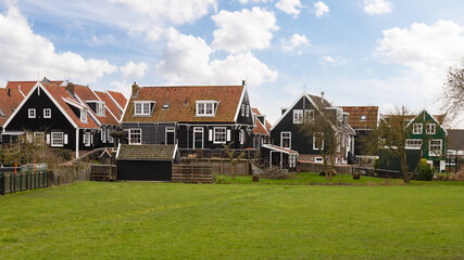 Traditional wooden houses near the small harbor in the picturesque fishing village of Marken in the Netherlands.