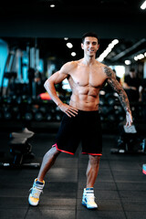 Fototapeta na wymiar Fitness trainer posing with muscular posture at gym. Fitness healthy life concept
