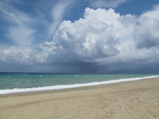 Cloud landscape. Cumulus clouds over the stormy sea on the beach. Italy, Calabria