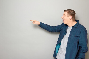 Portrait of goofy cheerful mature man pointing at something funny