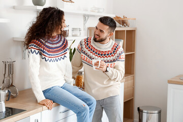 Happy young couple wearing warm sweaters at home