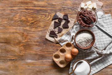 Bowl with flour and ingredients for preparing chocolate brownie on table