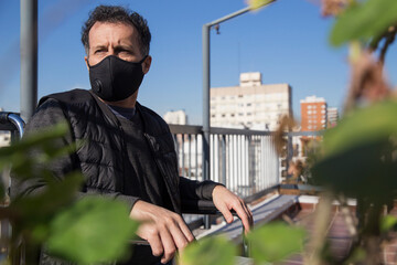 European man wearing a protective mask in a wheelchair isolate at home during covid19 variant...