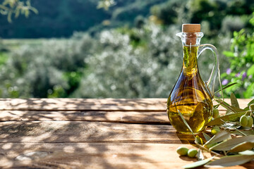 Extra virgin olive oil and olive branch in the bottle on wooden table in the olive grove. Healthy...