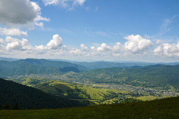 Obraz premium Beautiful mountain landscape with green forests, hills, meadow and village in the valley. Carpathian Mountains, Ukraine