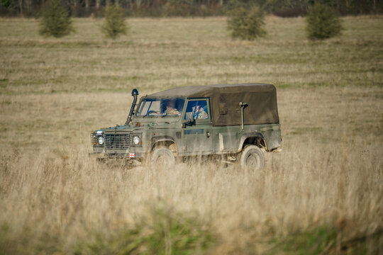 British Army Land Rover Defender 110 Wolf 4x4 In Action On A Military Exercise, Salisbury Plain UK