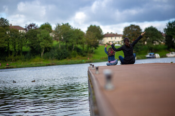 Mother and daughter have fun on a river pier in the popular park of Enniskillen in Northern Ireland.