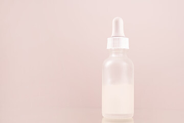 face serum oil dropper glass bottle with pipette on pink background close up