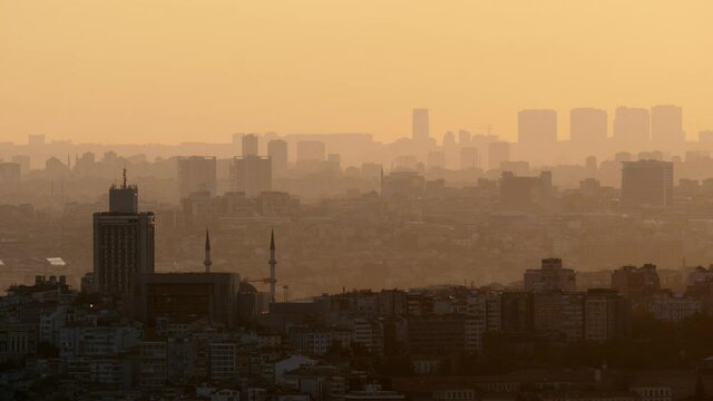 Dramatic view of evening Istanbul, city hills covered with buildings, visible in layers fading by distance. Telephoto perspective of city's European side, Taksim district on foreground