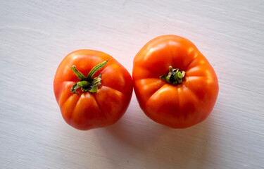 Two healthy tomatoes on a white background with top view