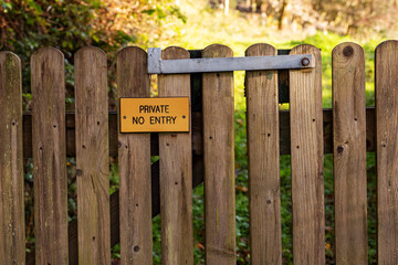 Wooden gate in a forest park with sign private no entry. Access to private property forbidden.