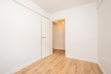 White bedroom with wooden flooring and no furniture