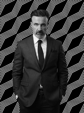 Black and white portrait of a stylish elegant senior businessman with a beard and casual business clothes against retro colorful pattern design background gesturing with hands