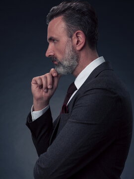 Frustrated middle aged elegant man Close up face of a stressed businessman wearing a stylish suit with eyes closed. Side shot