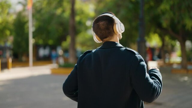 Young hispanic man smiling confident listening to music at park