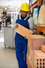 Male worker stacks insulation panels in a store