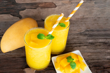 Mango juice fruit smoothies yogurt drink yellow healthy delicious taste in a glass slush for weight loss on wooden background.