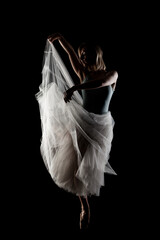ballerina with a white dress and black top posing on black background © Nikola Spasenoski
