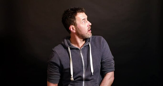 man looks to the side, surprised and frightened