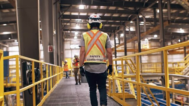 construction safety workers walking in slow motion through factory