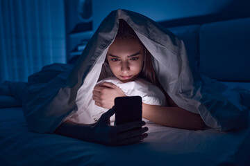 Young woman using cellphone at night - obrazy, fototapety, plakaty