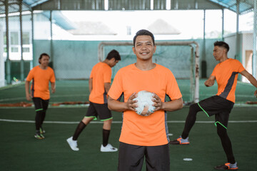 Male futsal player holding ball in front of the chest