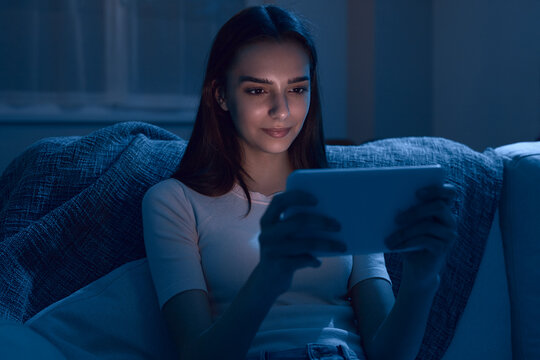 Woman watching video on tablet at night