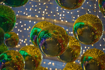 Hanging gold green ornaments ball with colorful blur background in a decorative tunnel