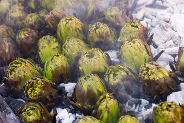 Fototapeta na wymiar Closeup of artichokes being grilled on ember. Healthy outdoor eating ..