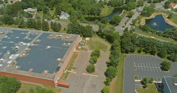 Aerial panoramic overview of solar system on a roof building warehouse an industrial zone ner American countryside small town